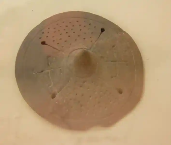 Two swastikas on a circular clay figure